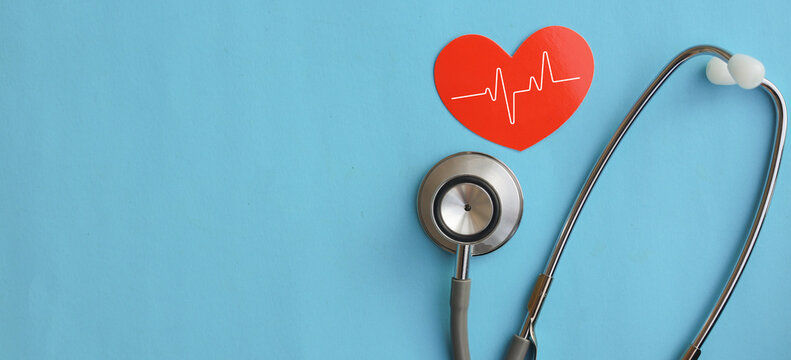 close up top view on red heart symbol and stethoscope on over blue background for design about ads or banner of insurance claim and health checkup following personal lifestyle concept