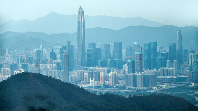 Hong Kong on hills surrounded by tropical forest. Megacity high-rise residential buildings and residential neighborhoods. Increasing population density due to upward housing growth. But city smog
