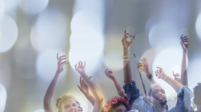 Vertical video: Crowd raising cups and waving while overlay clearing revealing faces at festival