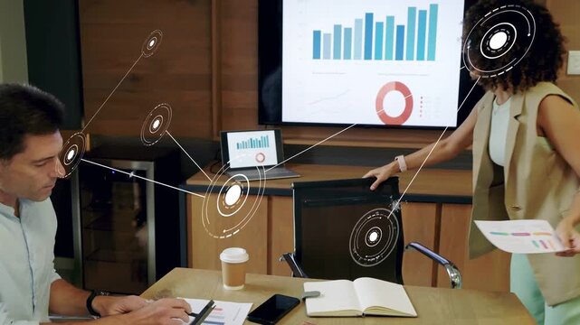 Woman checking business charts, rising to screen and pointing and explaining while AR linking data