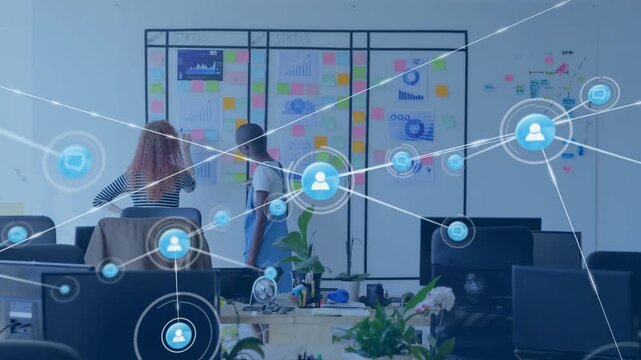Two colleagues pointing at glass board, causing growing icon net over notes for business planning