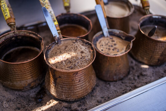 Traditional Turkish Coffee Brewing in Copper Cezve on Sand
