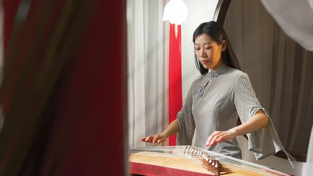 Dedication love of music musician playing traditional instruments, plucking strings of zither or guzheng with plectrum. The scene is set in a peaceful, natural environment, creating symphony of sound
