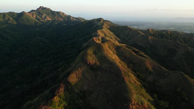 Mt Masapinit Toong Tuy Batangas Philippines mountain peak aligned with glowing sunset horizon creating a serene natural composition.