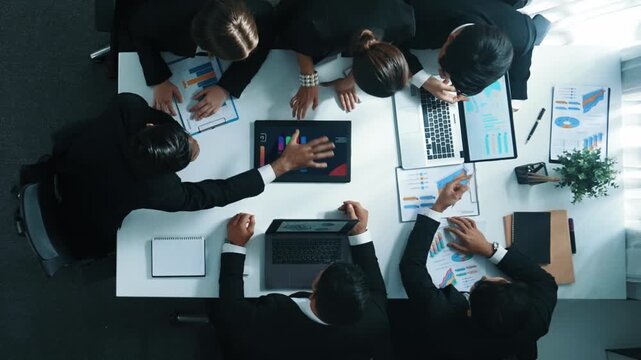Top view of smart business people brainstorm marketing idea at meeting table while compare stock market investment data between laptop and tablet. Business team planning financial plan. Directorate.