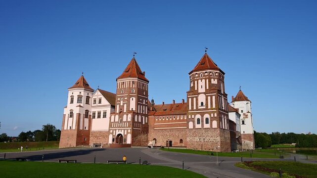 Mir Castle Complex in Belarus, UNESCO World Heritage site, medieval architecture landmark. Red brick fortress towers under blue sky, historical travel destination, European heritage tourism