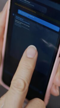 Vertical close-up of female hands using online medical or healthcare app chatbot on smartphone for flu symptoms, diagnosis and medications for treatment, tracing lines with finger