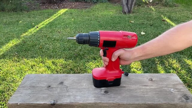 close up of hand pressing button to turn on cordless screwdriver tool activation moment power tool startup detail diy home repair and workshop equipment use