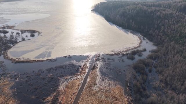 Aerial View of Partially Frozen Lake Hedemora with Brilliant Sun Reflection Dalarna Sweden