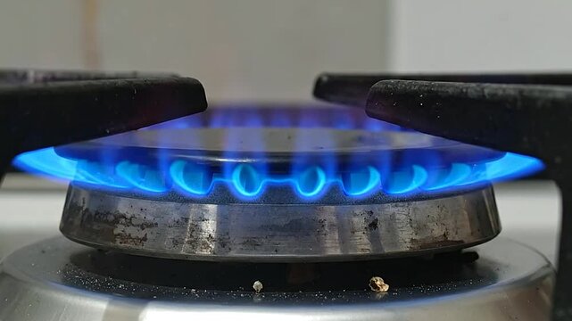 A close-up view of a bright blue flame burning on a generic cooking appliance surface