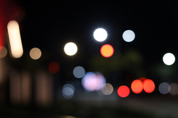 ​Abstract out of focus bokeh lights of heavy evening traffic on a busy city street at night. Bright red and white circular flares from car headlights and tail lamps create a vibrant urban atmosphere. © Jumain