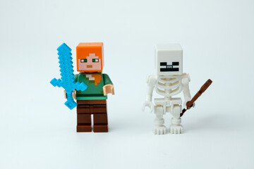 Fototapeta premium Two Minecraft toy figures standing side by side, including a character with a blue sword and a skeleton figure with a brown weapon, on a white background on Apr 13, 2026 in Jakarta, Indonesia
