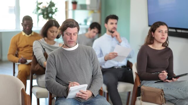 During lecture meeting, pupils listen to teacher, write down summary. Language courses, exam preparation, lectures and practical classes at school. Students are taking trial class in language courses