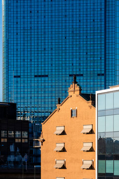 Modern urban contrast in Oslo skyline architecture featuring a historic gable beside a glass skyscraper facade creating a city story of change