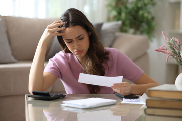 Worried woman checking invoice and accounting at home