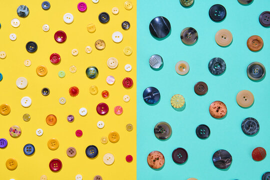 Assorted sewing buttons on yellow and blue background