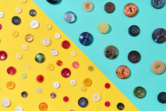 Assorted sewing buttons on yellow and blue background