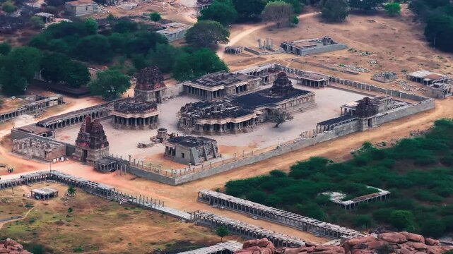 temple ruins with Shri Achyutarāya Swamy Temple, trees and Matanga Hill at vijayanagara empire, hampi, karnataka, india. day time, push back shot, tilt up shot, drone shot, 4k.