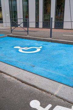 Urban street reserved space with blue disabled symbol shows accessibility parking marking on pavement supporting inclusive transport and access