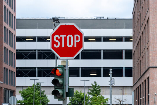Urban intersection with red stop sign highlights street traffic control road safety and regulation against modern building backdrop
