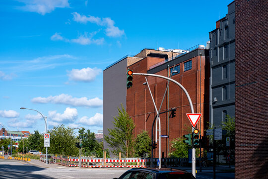 Yield sign at urban junction frames street intersection where traffic meets road priority in clear daylight creating calm city navigation scene