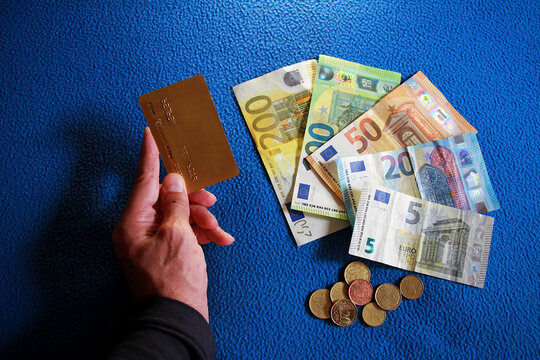 Tarjeta de cr&eacute;dito oro en pl&aacute;stico y dinero en efectivo cash en billetes de euro con monedas en transacci&oacute;n de compra