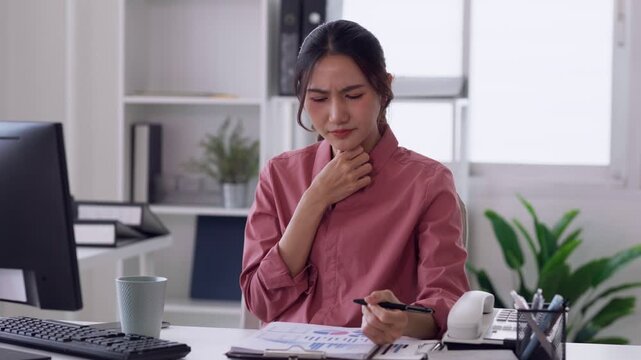 Asian adult woman coughing discomfort while working at office desk workplace environment health concern productivity issue professional illness