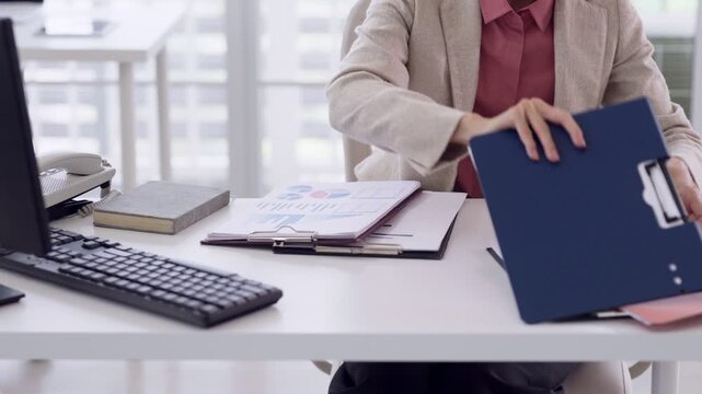 Adult Asian hands organizing business documents in office workspace managing charts reports data for corporate productivity