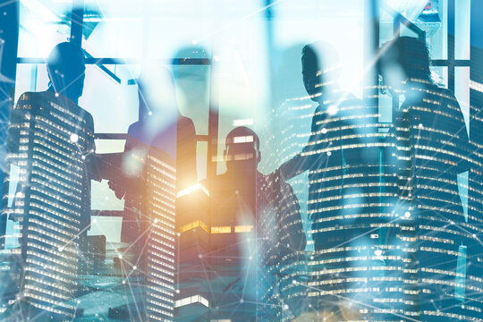 Business meeting with city skyline in background, bright light shining through large windows during the day