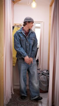Man Tests Outfit Choices Confidently. White Male Experiments With Trendy Clothing In Fitting Room