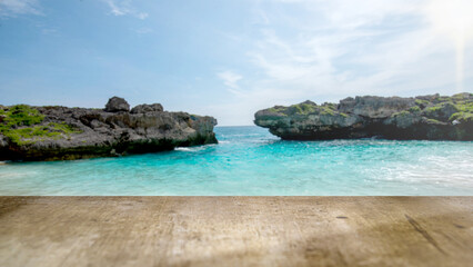 Naklejka premium Scenic tropical cove with clear turquoise water and rocky cliffs, seen from a rustic wooden table. Perfect for summer vacation, travel, and product placement backgrounds