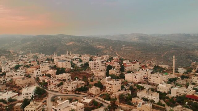 Breathtaking Drone Aerial View of a Traditional Iran Hillside Town at Sunset. Aerial Iran skyline of desert city wind towers. Iran Israel conflict and oil transportation Gap 