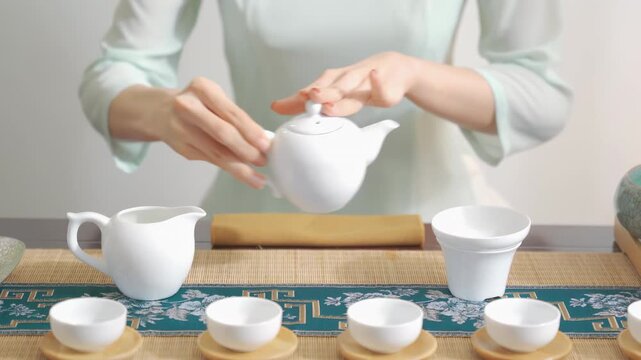 Professional hands of tea master prepare traditional ceremony chahe with black tea brewing technique over table serving guests drink in classic teahouse for relaxing cultural experience, teapot teacup