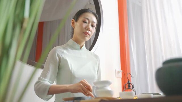 Tea master preparing traditional ceremony chahe with green tea brewing technique over the table for serving guests in classic teahouse for relaxing cultural experience with teapot teacup