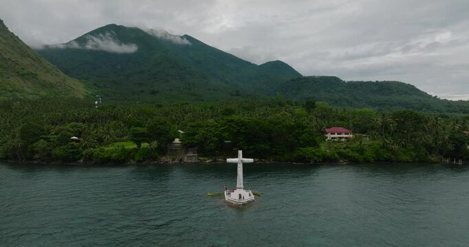 Drone view of a large Cross in turquoise sea water in Camiguin Island. Sunken Cemetery. Philippines.