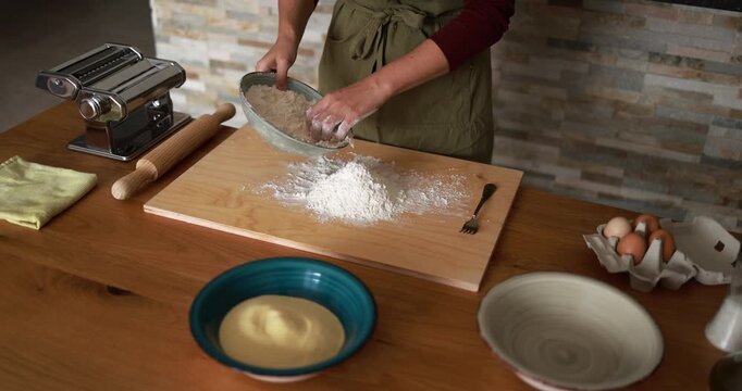 Woman preparing dough for pasta at home - Handmade food and italian culture concept 