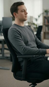 Man sitting with correct posture at office chair, ergonomic workplace setup, healthy sitting position during work, business environment and productivity concept