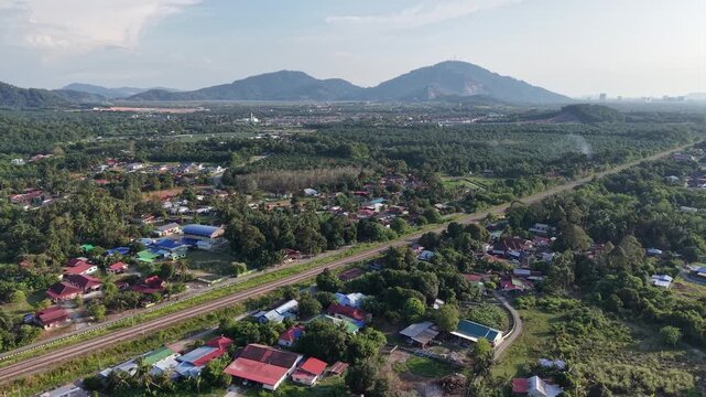 Drone footage showing plantation, village, railway and hills near Kubang Semang, Malaysia.