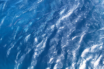 Obraz na płótnie Canvas A close-up, top view of blue sea waves.