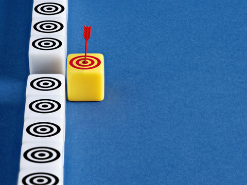 Yellow block with arrow hitting bullseye standing out, achieving a specific goal or goal selection