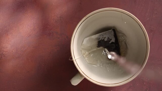 A cup of tea with a tea bag viewed from above, surrounded by bubbles, top view. Concept of warmth, relaxation, and lifestyle, ideal for use in culinary and wellness marketing.