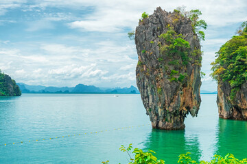 Close up view of limestone karst formation rising from sea in Phang Nga Bay, Thailand. James Bond island surrounded by calm tropical water. Travel destination and geology concept in Southeast Asia © samael334