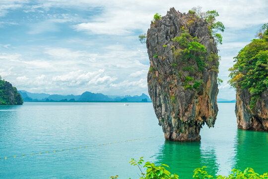 Close up view of limestone karst formation rising from sea in Phang Nga Bay, Thailand. James Bond island surrounded by calm tropical water. Travel destination and geology concept in Southeast Asia