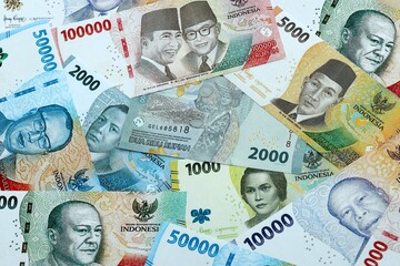 Indonesian rupiah money banknotes pile on table. Indonesia bills of IDR currency close up © Larysa