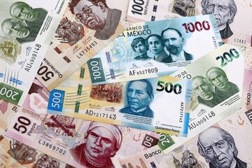 Obraz premium Mexican peso money banknotes pile on table. Mexico bills of MXN currency close up