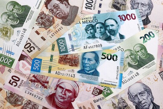 Mexican peso money banknotes pile on table. Mexico bills of MXN currency close up