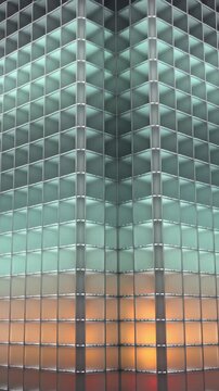 Vertical video: Moving camera revealing glass block corner in lobby, showing shifting LED bands