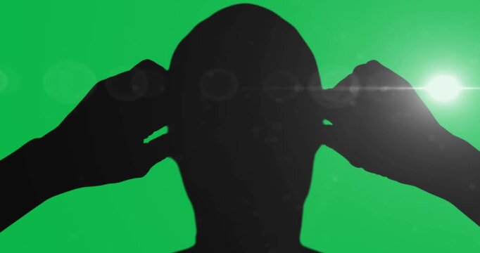 Silhouette of male swimmer against spot of light on black background