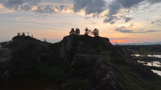 Drone footage of Frog Hill rock formations and ponds at sunset in Kubang Semang.