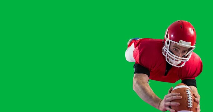 Caucasian male rugby player wearing a helmet catching a rugby ball against black background